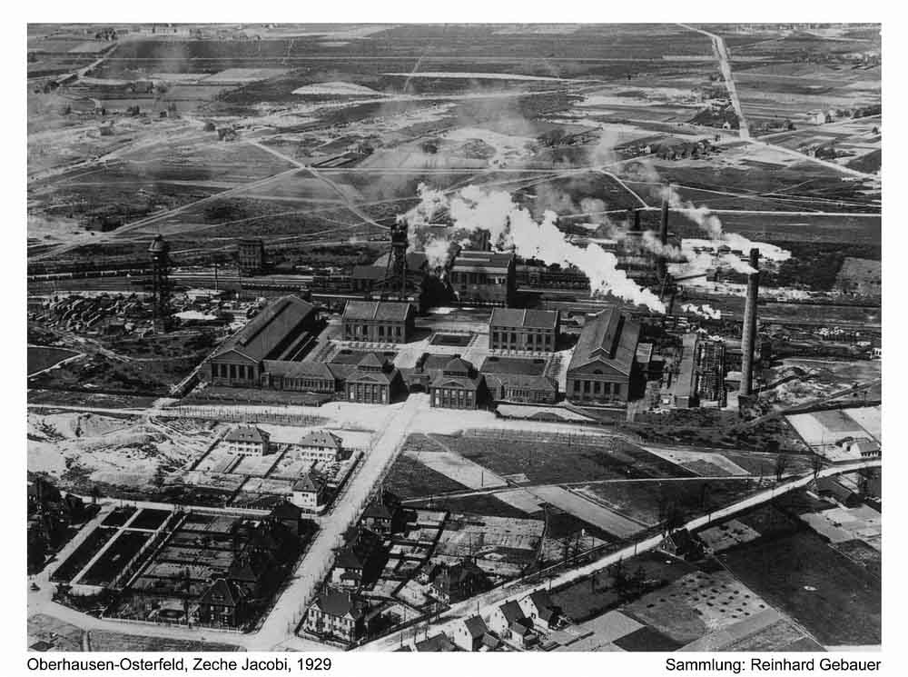Die Zeche Jacobi mit den Häusern für die "Beamten" im Jahre 1929. Die Jacobistraße endet vor dem Torhaus. Die jungen Platanen am Straßenrand sind deutlich zu erkennen. Die diagonal verlaufende Straße ist die Waldstraße (heute Im Fuhlenbrock). Zeche Jacobi 02
